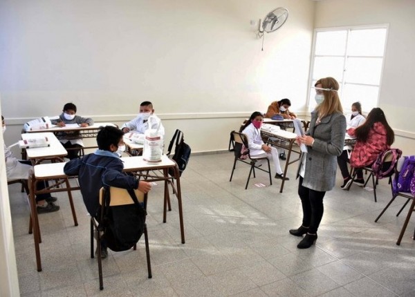 Maestra y alumnos con distancia social